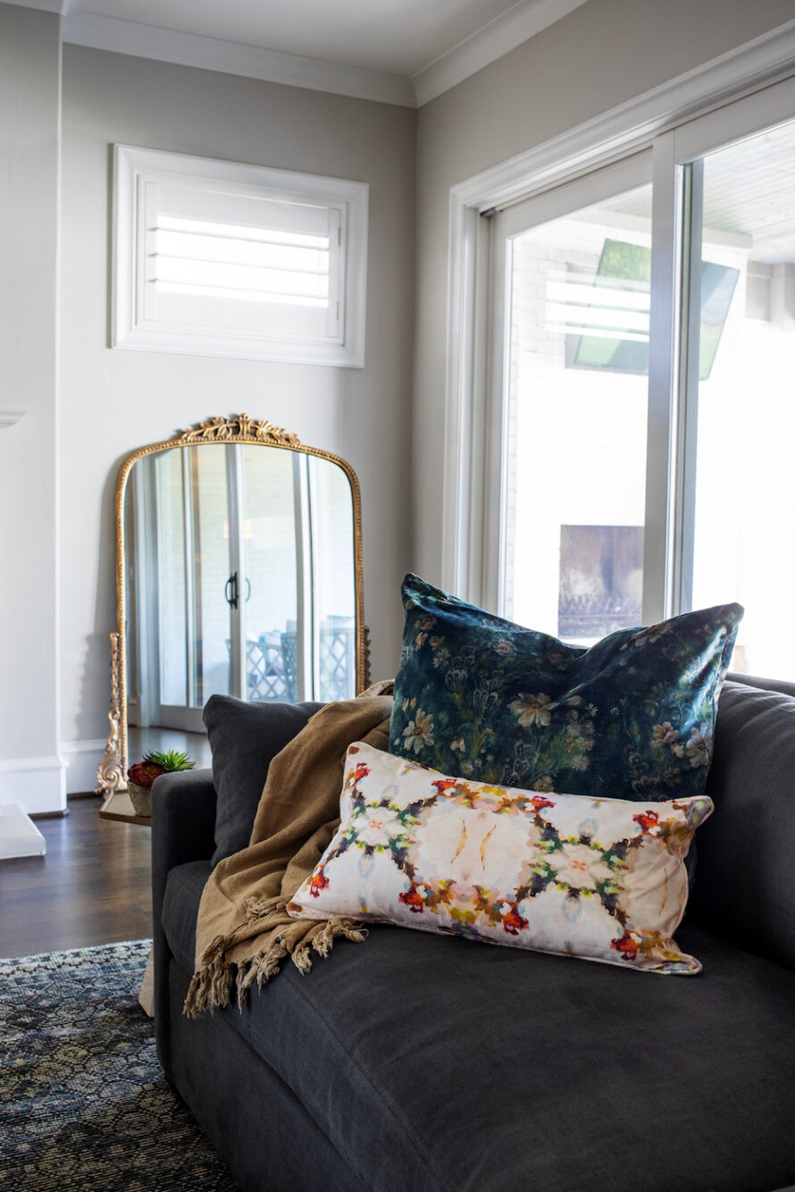 gold-frame-mirror-leaning-sofa-accent-pillows