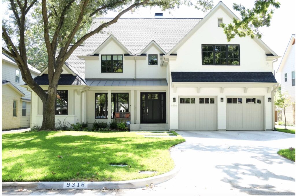 Gabled white house with a dark metal roof in suburban Dallas, TX. 