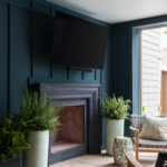 patio design with custom painted hardie board and batten with a black stone fireplace surroud