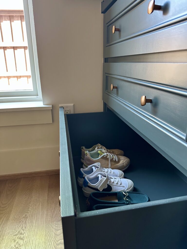 A shoe drawer provides a tucked away solution.