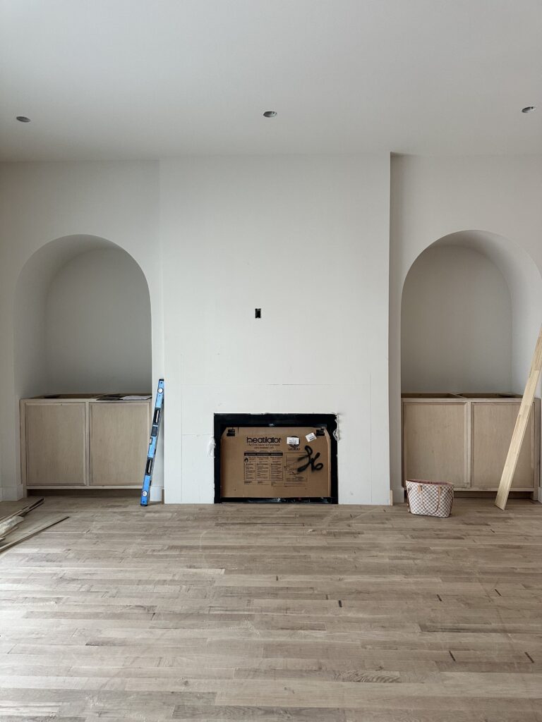 Fireplace framing and arched wall niches during the construction phase of a new custom home build